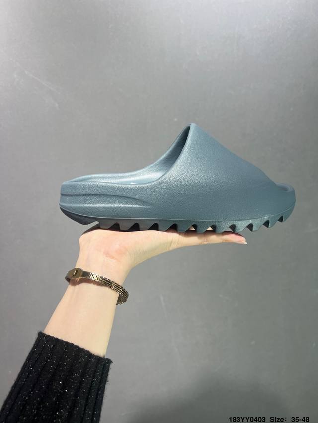 Adidas Originals Yeezy Slide 夏季单品 整体造型圆润厚重 露脚趾的宽鞋面构造 橡胶中底搭载锯齿型的外底 厚实百搭 给人一种看起来就非