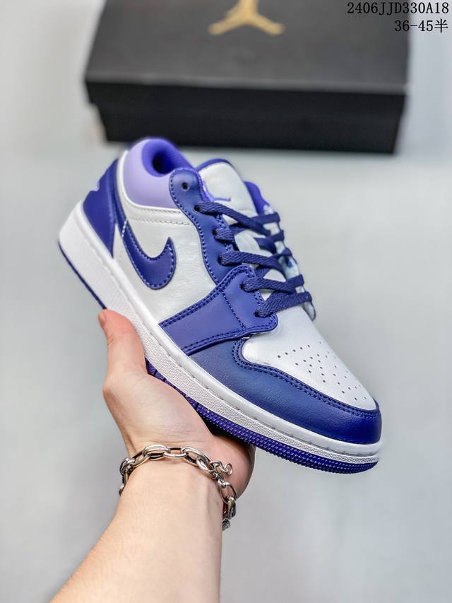Air Jordan 1 Low “True Blue” 整体的白色框架搭配上鞋头的灰色荔枝纹皮革，再加上鞋身中段黑色皮质材料的 Nike Swoosh，质感不